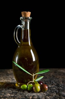 Zeytinyağı ve taze zeytin eski masada.