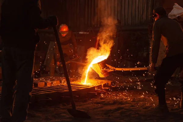 Men work with hot metal in a steel factory Stock Image