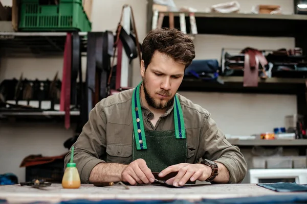 A master works with genuine leather — Stock Photo, Image