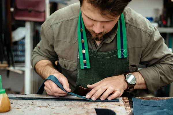 A master works with genuine leather in the workshop
