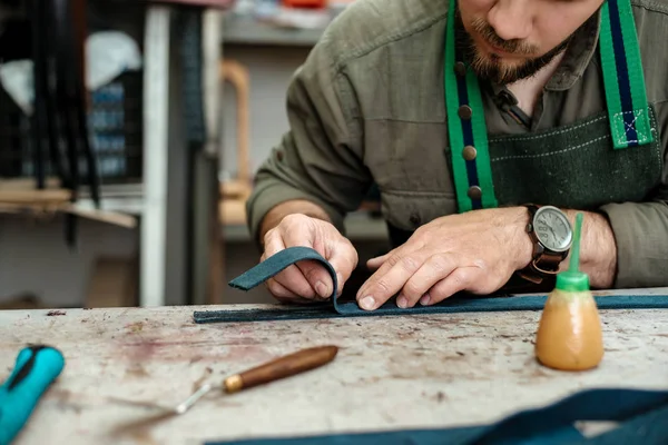 A master works with genuine leather in the workshop — Stock Photo, Image