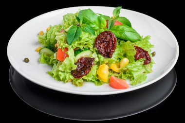 Taze ve kurutulmuş domates, biber, fesleğen izole siyah arka plan üzerine vejetaryen salatası