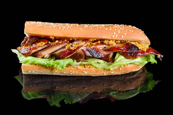 Sandwich de costela de churrasco gigante com folha de salada e mostarda francesa em baguete. isolado sobre um fundo preto — Fotografia de Stock