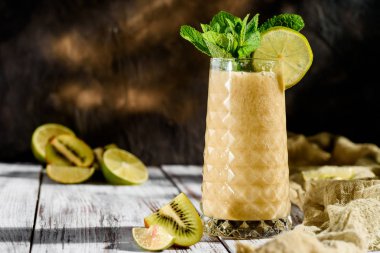 nane hafif ahşap zemin ile süslenmiş güzel bir cam apineapple ve Kivi Meyve gelen lezzetli smoothies