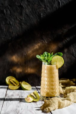 nane hafif ahşap zemin ile süslenmiş güzel bir cam apineapple ve Kivi Meyve gelen lezzetli smoothies