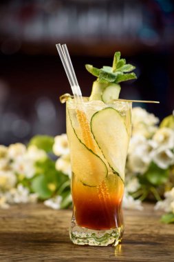 kokteyl çiçek bir arka plan üzerinde ahşap bir masa üzerinde salatalık ile yaz