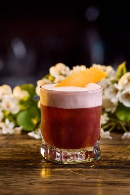 Yaz katmanında dekore portakal kabuğu kokteyl. bir çiçek arka plan üzerinde