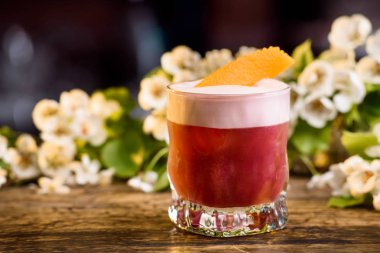 Yaz katmanında dekore portakal kabuğu kokteyl. bir çiçek arka plan üzerinde