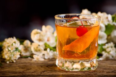 viski ve bir bar portakal kabuğu kokteyl çiçek bir arka plan üzerinde sayaç