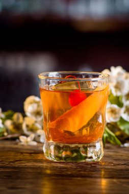 viski ve bir bar portakal kabuğu kokteyl çiçek bir arka plan üzerinde sayaç