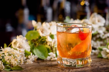 viski ve bir bar portakal kabuğu kokteyl çiçek bir arka plan üzerinde sayaç