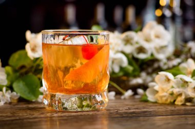 viski ve bir bar portakal kabuğu kokteyl çiçek bir arka plan üzerinde sayaç