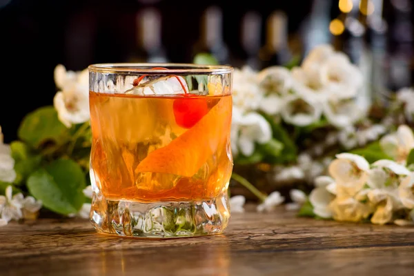 viski ve bir bar portakal kabuğu kokteyl çiçek bir arka plan üzerinde sayaç