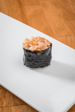 Gunkan sıcak bir arka plan üzerinde beyaz bir tepside yengeç. Japon geleneksel suşi