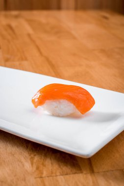 sıcak bir arka plan üzerinde beyaz tabakta izole somon suşi. yakın çekim 