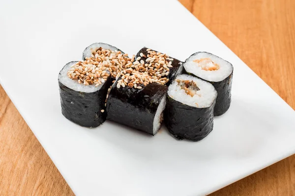 Maki ahşap arka plan üzerinde beyaz tabakta izole yılan balığı ile alır. yakın çekim