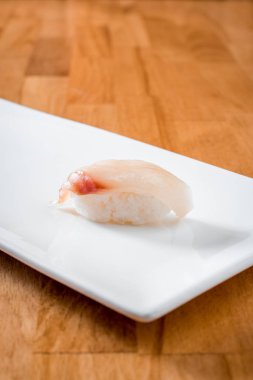 ahşap arka plan üzerinde beyaz tabakta izole orfoz suşi. yakın çekim. Uzay