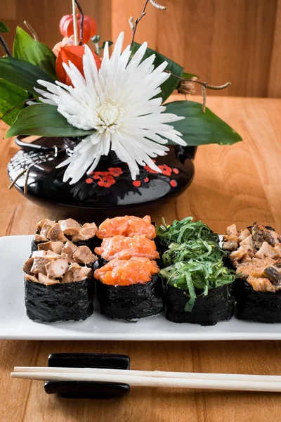 Gunkan σούσι σετ με σολομό, Χέλι, chukka και κοτόπουλο κρέας σε ένα λευκό πιάτο. ξύλινα bacground. Παραδοσιακή ιαπωνική κουζίνα. κοντινό πλάνο — Φωτογραφία Αρχείου
