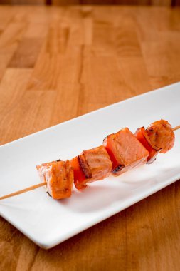 Beyaz bir plaka üzerinde ızgara somon kebabı. izole. yakın çekim