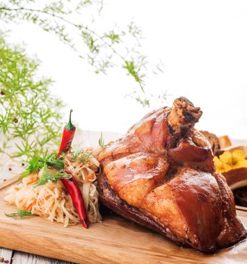 Kavrulmuş domuz knuckle kızarmış haşlanmış lahana ve ahşap kesme tahtası üzerinde biber ile. yakın çekim. izole