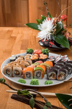 Harika sushi set. Beyaz bir plaka üzerinde rulo somon balığı, yılanbalığı, avokado ve ton balığı. Japon mutfağı