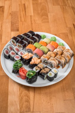 Harika sushi set. Beyaz bir plaka üzerinde rulo somon balığı, yılanbalığı, avokado ve ton balığı. Japon mutfağı