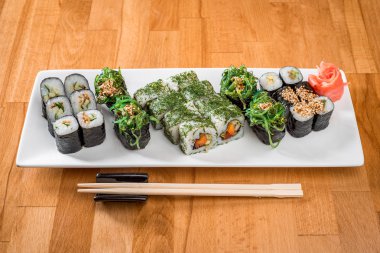 Somon, ton balığı, avokado ve gunkan chuka ile rulo beyaz tabakta kümesi. yakın çekim