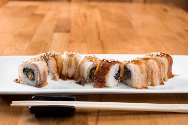 yılan balığı ile izole hafif bir arka plan üzerinde beyaz bir plaka rulo. yakın çekim