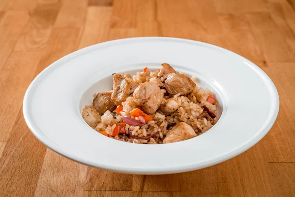 Жареный рис с мясом и овощами в белой тарелке. макро — стоковое фото
