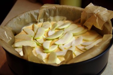 Ham pasta pişirme için hazırlanan bir kalıp içinde elma parçaları ile. Fırın için hazırlanan Hamur Mayaları.