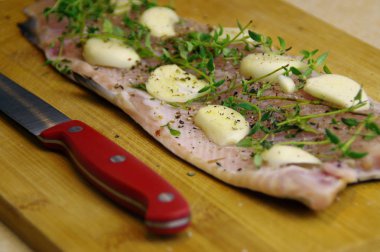 Taze çiğ alabalık pişirme için hazır. Otlar, sarımsak ve baharat ahşap oyun tahtası ile balık