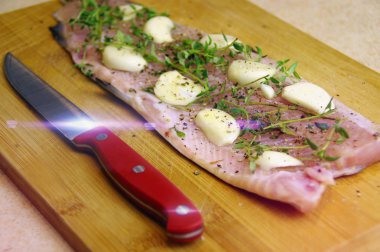 Pişirme için hazırlanan taze çiğ alabalık. Otlar, sarımsak ve baharat ahşap oyun tahtası ile balık