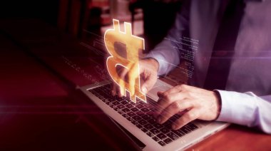 Bitcoin hologramı ile klavyede yazan adam