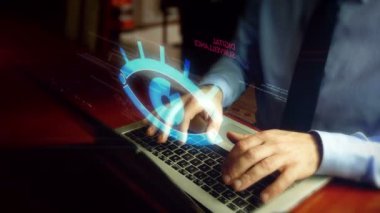 Hacker klavye üzerinden siber casus göz hologram ekran ile dizüstü bilgisayarda yazma. Dijital gözetim, casusluk, hack ve gizlilik sembolü fütüristik kavramın ihlali ile Adam. El kamera sallamak.