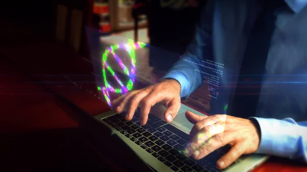 Man typing on keyboard with DNA helix hologram