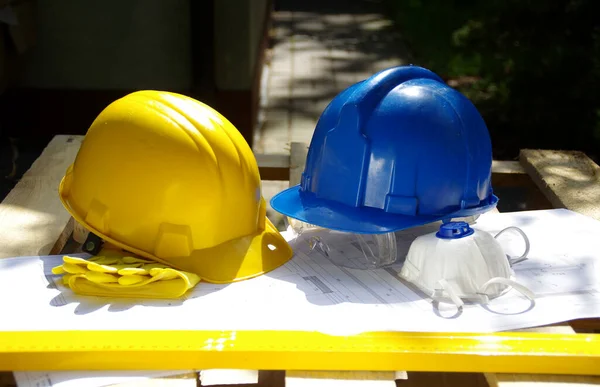 Yellow and blue protective helmet. Personal protective equipment. Safety at the construction site.