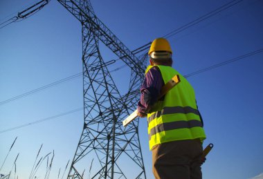 Güç hattı denetimi sırasında mühendis. Elektrikçi iş başında. Enerji santrallerinden enerji üretimi ve tedariği.