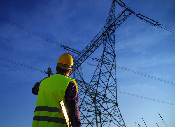 Engineer during power line inspection. Electrician at work. Production and supply of energy from power plants.