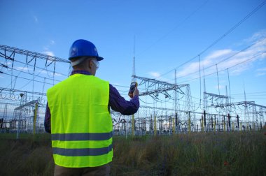 Miğferli bir mühendis ve bir metre. Elektrik enerji üretimi ve enerji endüstrisi.