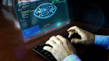 Masadaki hologram ekranında siber gözle klavyede yazan adam. Kontrol ve gözetim, dijital casusluk, gözetleme ve canlandırma konsepti. El sıkışma kamerası.