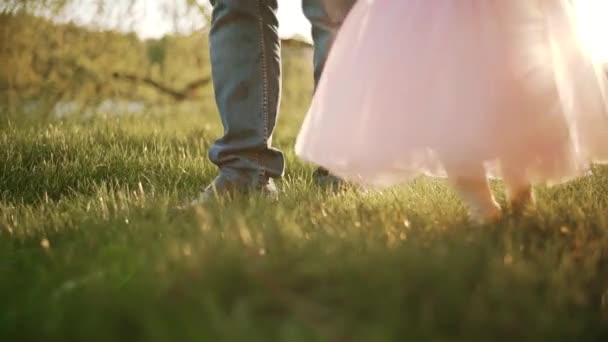 Die ersten Schritte des Kindes auf dem Gras. Zeitlupe — Stockvideo