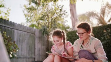 Mutlu gülümseyerek anne ve çocuk eğlenmek ve çizim resimleri açık havada yaz güneş Bahçe