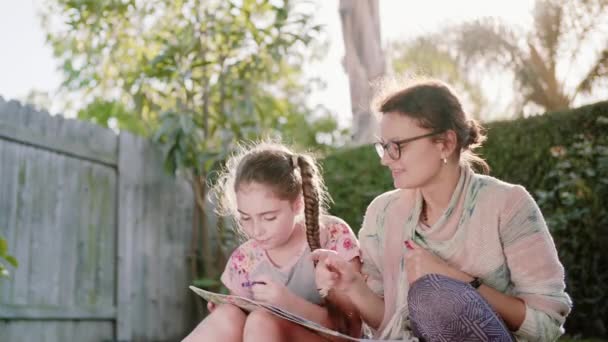 Felice Sorridente Madre e Bambino Divertimento e Disegno Immagini all'aperto in giardino in estate. macchina fotografica immobile — Video Stock