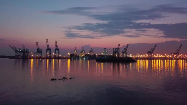 Luchtfoto drone. Vlucht naar Containerhaven met schepen en kranen bij zonsondergang — Stockvideo