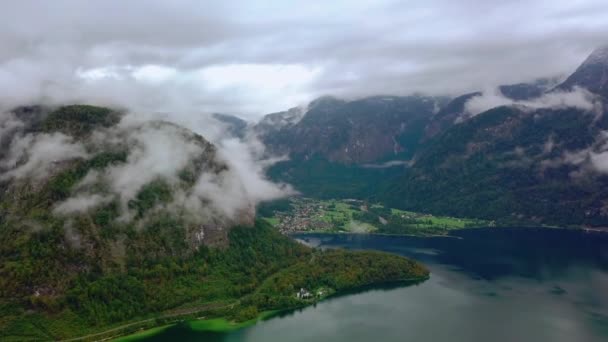 Flygfoto från drone vid sjön i Hallstatt omgiven av berg i moln. Österrike natur. — Stockvideo