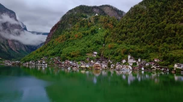 Aerial panoramaut Visa från drone vid sjön i Hallstatt omgiven av berg i moln. Österrike natur. — Stockvideo