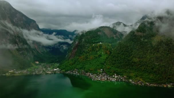 Luchtfoto panorami uitzicht vanaf drone aan het meer van de Hallstatt vliegen door de wolken omgeven door bergen in de wolken. Oostenrijk-natuur. — Stockvideo