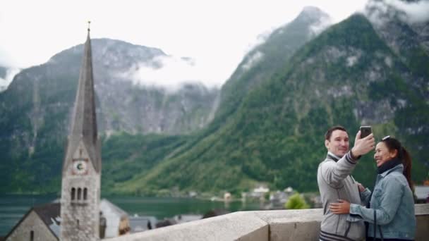 Citas pareja joven feliz en el amor tomando foto autorretrato en la hermosa montaña Hallstatt — Vídeos de Stock