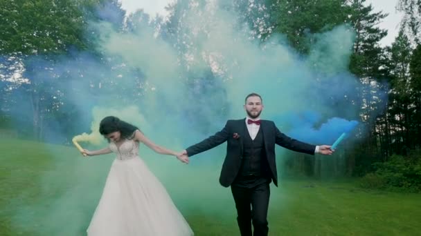 Matrimonio coppia corre fumo di colore nella foresta. Rallentatore — Video Stock