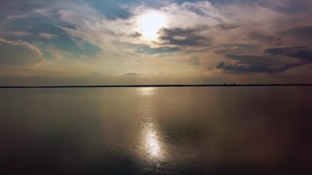 Filmato aereo del drone del lago contro il cielo. La riflessione delle nuvole sta cadendo nell'acqua. Veloce inseguimento colpo di acqua increspata e sul lago. spostare la fotocamera verso il basso — Video Stock